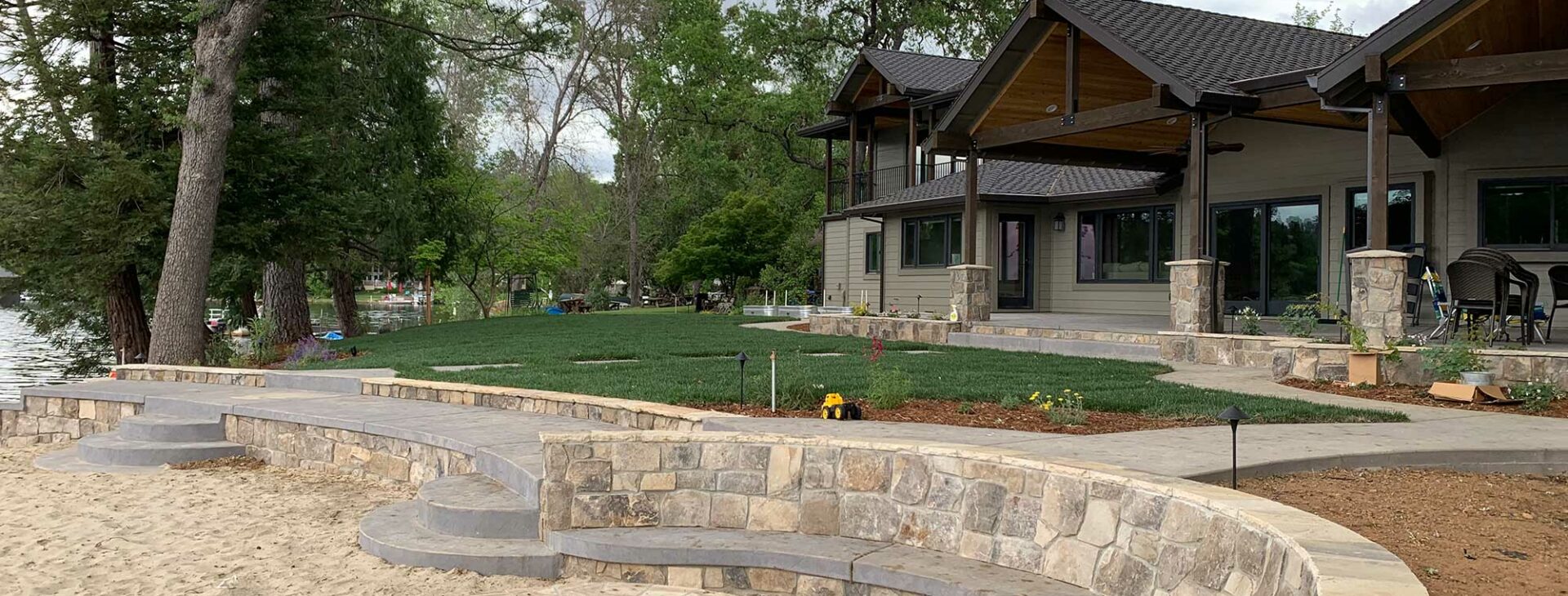 Landscaping and hardscaping with a fire pit, lakeside environment.